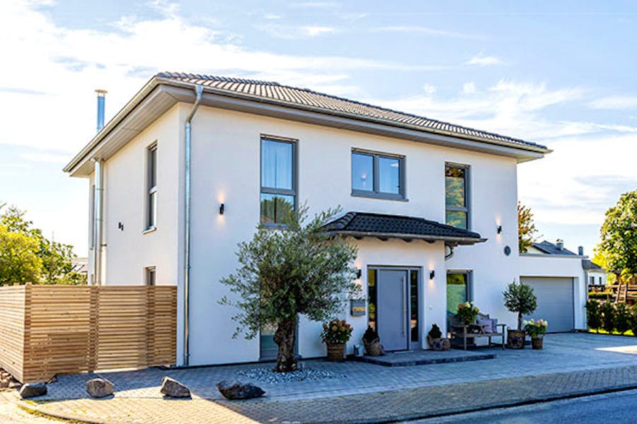 Klare Linien und individuell gewählte Details prägen die Architektur dieses Hauses. Der großzügig angelegte Eingangsbereich vermittelt bereits beim Betreten ein offenes Raumgefühl. Bodentiefe Übereckfenster bringen Licht aus mehreren Richtungen in das Gebäude und schaffen interessante Sichtbeziehungen zwischen Innen- und Außenraum.

Ein besonderer Blickfang ist der offene Luftraum. Er verbindet die Geschosse optisch miteinander und verstärkt die Großzügigkeit der Innenräume. Natürliche Materialien treffen auf dunkle Farbtöne und bewusst gesetzte Kontraste.