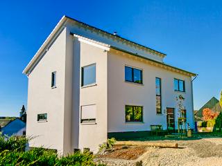 Massivhaus Attraktives Haus mit versetztem Pultdach von RheinMassiv Massivhäuser, Pultdachhaus Außenansicht 2